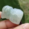 Una mano sosteniendo un colgante de jade.