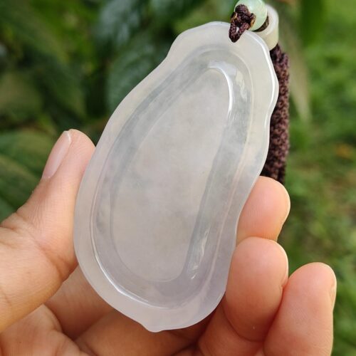a hand holding a white pendant