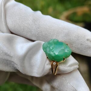 a hand wearing a glove holding a ring
