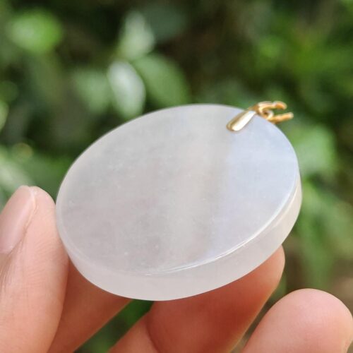 a hand holding a round white object