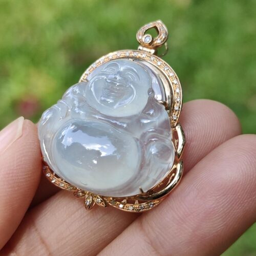 a hand holding a jade pendant