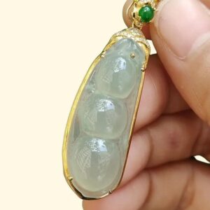 une main tenant un pendentif en jade