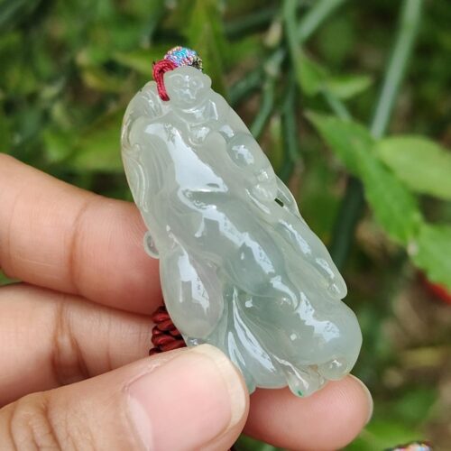 एक हाथ में जेड पेंडेंट थामे हुए
