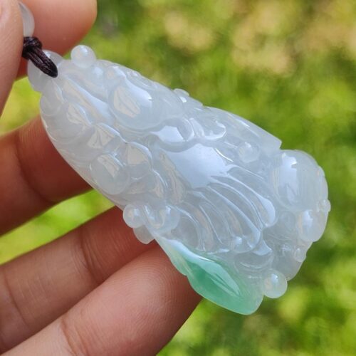Una mano sosteniendo un colgante de jade.