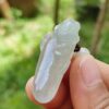 a hand holding a small white object