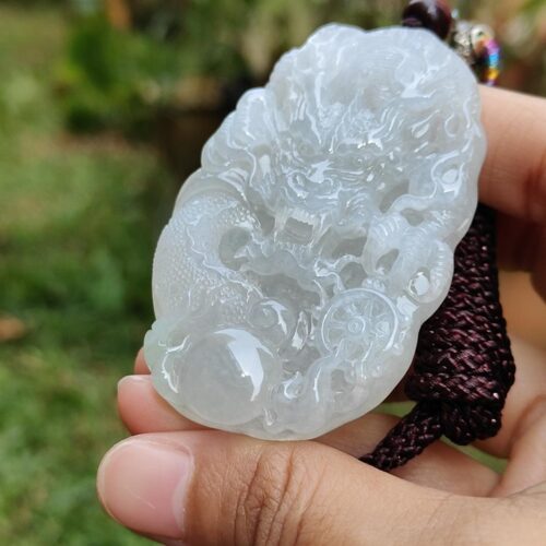 Una mano sosteniendo un colgante de jade.