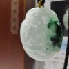 a jade pendant with a person sitting on it