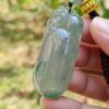 Una mano sosteniendo un colgante de jade.