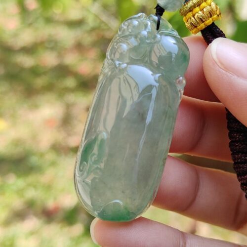 Una mano sosteniendo un colgante de jade.