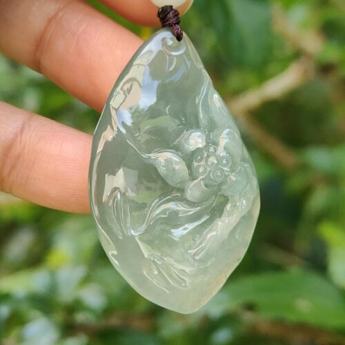 Una mano sosteniendo un colgante de jade.