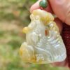 Una mano sosteniendo un colgante de jade.