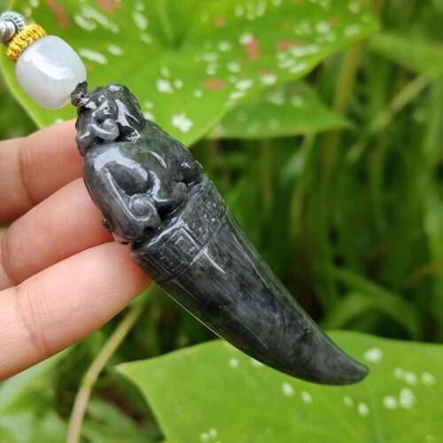 a hand holding a jade pendant