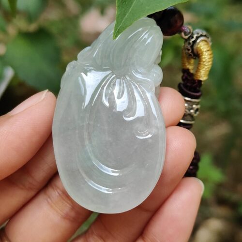 Una mano sosteniendo un colgante de jade.
