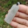 Una mano sosteniendo un colgante de jade.