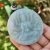 Una mano sosteniendo un medallón de jade.