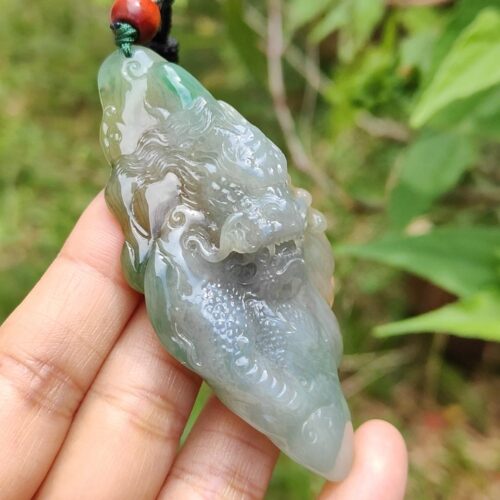 Una mano sosteniendo un colgante de jade.