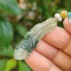 một bàn tay cầm một chiếc vòng cổ ngọc bích