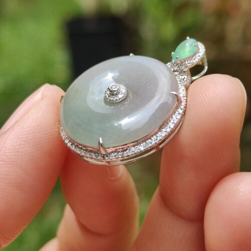 Una mano sosteniendo un colgante de jade.