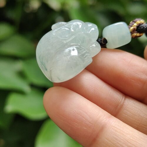 a hand holding a jade necklace