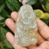 a hand holding a jade pendant