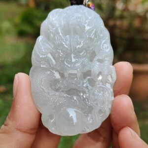 Una mano sosteniendo un colgante de jade.