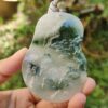 Una mano sosteniendo un colgante de jade.