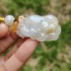 a hand holding a white and yellow bead