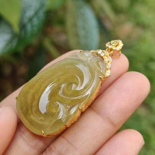 a hand holding a jade pendant
