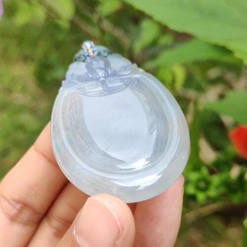 một bàn tay cầm một vật bằng ngọc bích