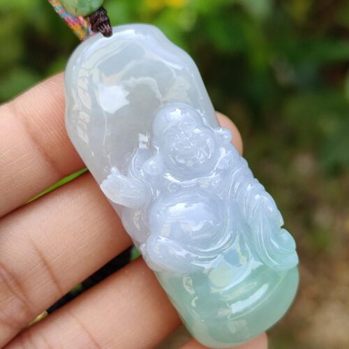 a hand holding a jade pendant