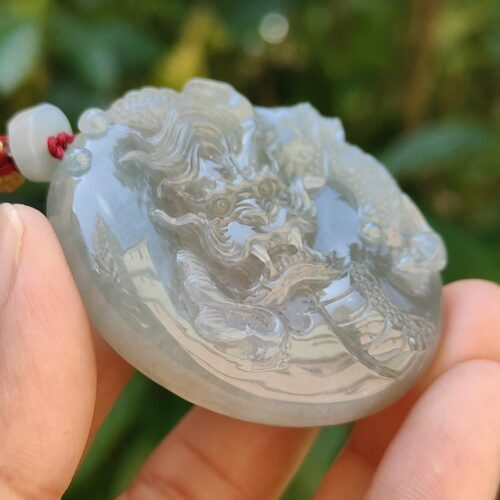 Una mano sosteniendo un colgante de jade.