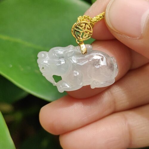 một bàn tay cầm một mặt dây chuyền ngọc bích