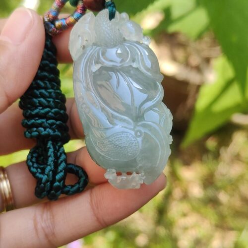 翡翠のペンダントを持つ手