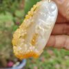 a hand holding a piece of white and yellow stone