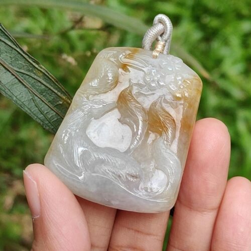 Una mano sosteniendo un colgante de jade.