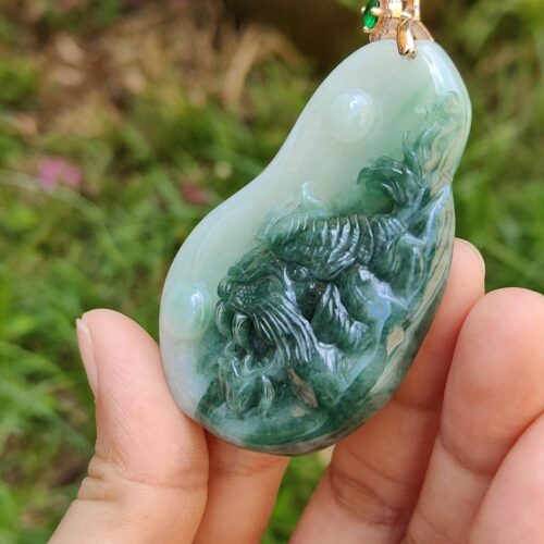 une main tenant un pendentif en jade