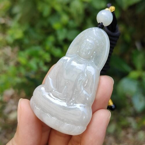 Una mano sosteniendo un colgante de jade.