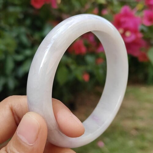 一只手拿着一枚白色的戒指