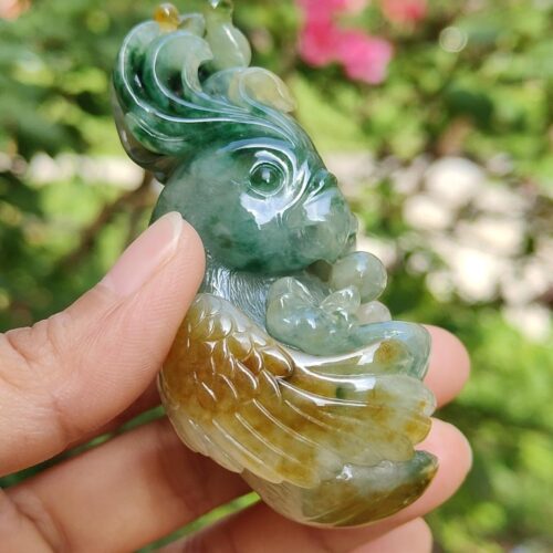 a hand holding a jade bird