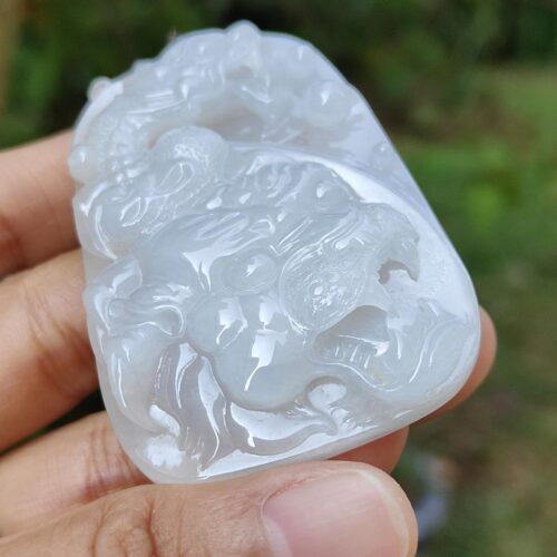 a hand holding a white jade object