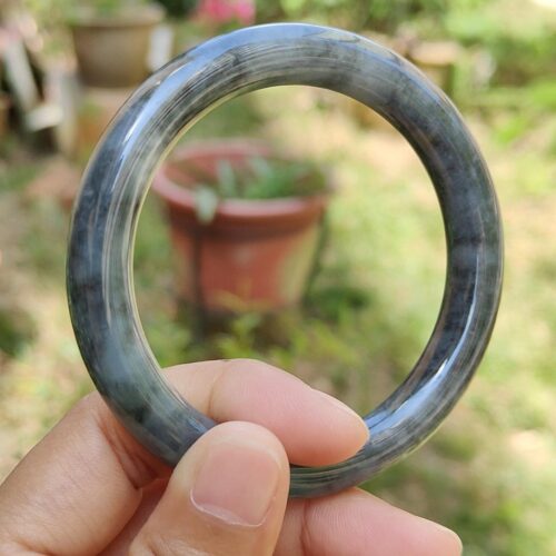 a hand holding a round stone ring