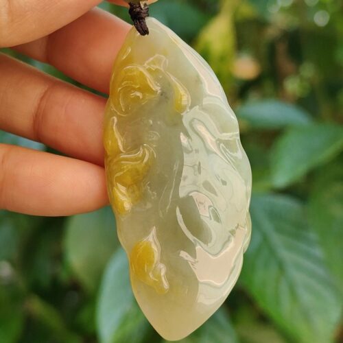 Una mano sosteniendo un colgante de jade.