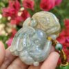 a hand holding a jade elephant
