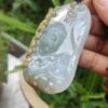 a hand holding a jade pendant
