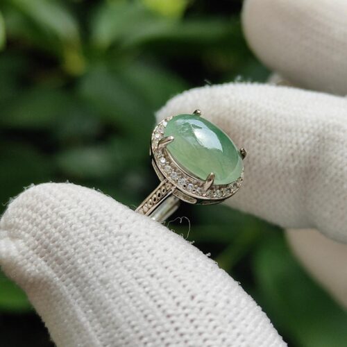 a hand wearing white gloves holding a ring