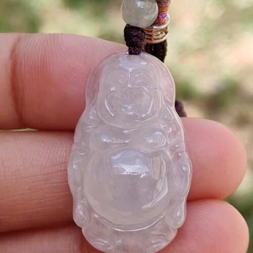 a hand holding a jade pendant