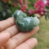 a hand holding a jade animal