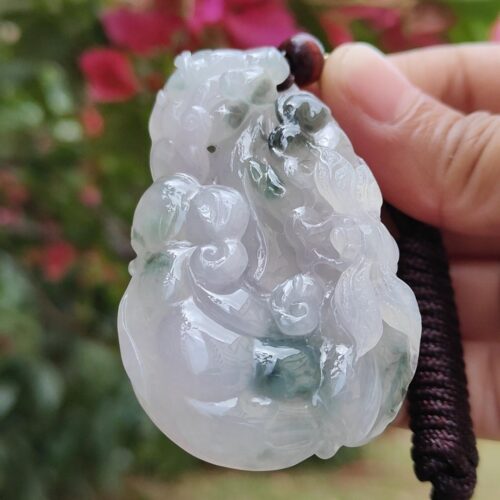 Una mano sosteniendo un colgante de jade.