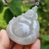 Una mano sosteniendo un colgante de jade.