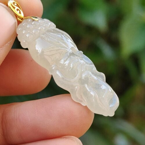 Una mano sosteniendo un colgante de jade.